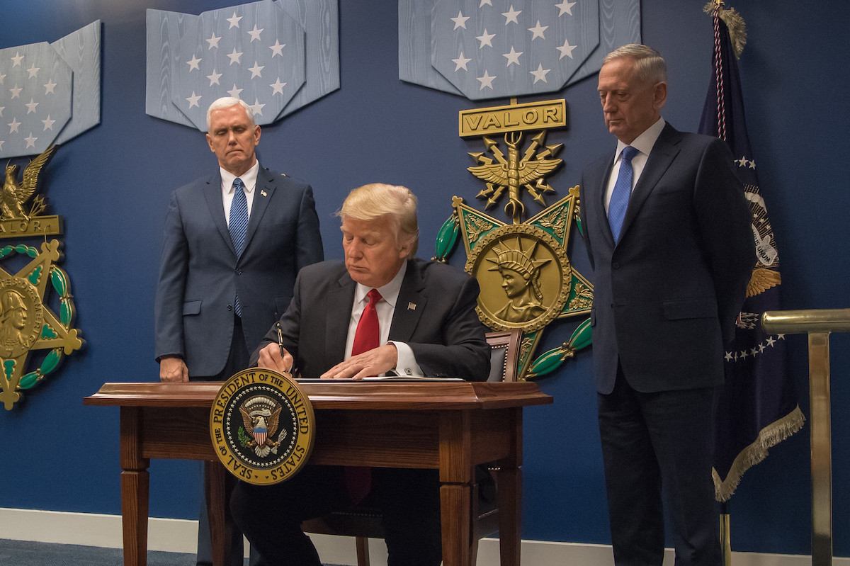 U.S. President Donald Trump signing the order at the Pentagon, with Vice President Mike Pence (left) and Secretary of Defense Jim Mattis. Source: U.S. Secretary of Defense Flickr