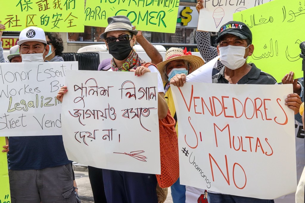 
            Street vendors hold signs in Spanish, English and other languages in a protest against undue fines in the Bronx.